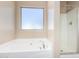 Bathroom with soaking tub, shower, and a window for natural light at 3482 W Mineral Butte Dr, San Tan Valley, AZ 85144