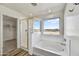 Bathroom with walk-in shower, soaking tub, and a window at 37536 W Patterson St, Maricopa, AZ 85138