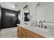 Modern bathroom with double vanity, marble countertops, and black tile at 4129 E Eugie Ave, Phoenix, AZ 85032