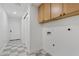 Bright laundry room with wood cabinets and checkerboard floor at 4129 E Eugie Ave, Phoenix, AZ 85032