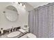 Bathroom with a decorative shower curtain, a round mirror, and sleek vanity at 4968 E Grandview Rd, Scottsdale, AZ 85254