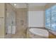 Bathroom with glass shower and a soaking tub with large window at 4968 E Grandview Rd, Scottsdale, AZ 85254