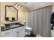 Bathroom boasts granite vanity and black and white shower curtain at 4968 E Grandview Rd, Scottsdale, AZ 85254