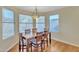 Bright dining area with a wooden table, six chairs and three windows with white blinds at 4968 E Grandview Rd, Scottsdale, AZ 85254