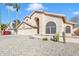 Well-kept home with an arched entryway, three-car garage, desert landscaping, and towering palm trees at 4968 E Grandview Rd, Scottsdale, AZ 85254