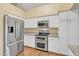 Kitchen featuring stainless appliances, white cabinets, and granite countertops and backsplash at 4968 E Grandview Rd, Scottsdale, AZ 85254