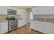 Modern kitchen with stainless steel appliances, white cabinets, and granite countertops at 4968 E Grandview Rd, Scottsdale, AZ 85254