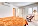 Bright bedroom with orange comforter and a sitting area at 5122 E Shea Blvd # 1030, Scottsdale, AZ 85254