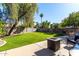 Large backyard with grassy lawn, patio, fire pit, and seating at 553 S Meadows Dr, Chandler, AZ 85224