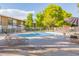 Sparkling community pool with patio furniture and umbrellas at 6125 E Indian School Rd # 180, Scottsdale, AZ 85251