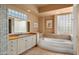 Elegant bathroom with a large soaking tub, double vanity, and glass block windows at 6358 E Evening Glow Dr, Scottsdale, AZ 85266