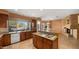 Spacious kitchen featuring granite island, wood cabinetry, and a fireplace at 6358 E Evening Glow Dr, Scottsdale, AZ 85266