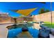 Inviting kidney-shaped pool with rock features and shade sail at 6414 W Villa Linda Dr, Glendale, AZ 85310