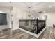 Elegant upstairs hallway with dark wood railing and chandelier at 6414 W Villa Linda Dr, Glendale, AZ 85310