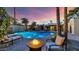 Night view of a freeform pool with fire pit and lounge chairs at 7258 E Manzanita Dr, Scottsdale, AZ 85258