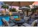 Night view of a poolside patio with seating and umbrellas at 7258 E Manzanita Dr, Scottsdale, AZ 85258