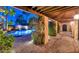 Night view of a resort-style pool with brick patio and covered walkway at 7258 E Manzanita Dr, Scottsdale, AZ 85258