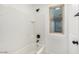 Bathroom with shower/tub combo and tiled walls at 7827 W Cypress St, Phoenix, AZ 85035