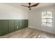 Bright bedroom with large window, ceiling fan, and green accent wall at 7870 W Cheryl Dr, Peoria, AZ 85345