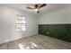 Bright bedroom with wood-look floors, large window, and stylish green accent wall at 7870 W Cheryl Dr, Peoria, AZ 85345