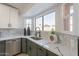 Modern kitchen features marble countertops, green cabinets, and herringbone backsplash at 7870 W Cheryl Dr, Peoria, AZ 85345