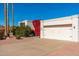 White stucco single story home with attached two car garage and red flowering bushes at 8602 E San Alfredo Dr, Scottsdale, AZ 85258