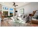 Relaxing living room featuring a light gray sectional sofa, large windows, and wood flooring at 8602 E San Alfredo Dr, Scottsdale, AZ 85258