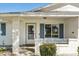 Inviting ranch home exterior featuring a covered entryway, blue shutters, and well-manicured landscaping at 9518 W Shasta Dr, Sun City, AZ 85351