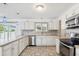 Modern kitchen featuring white cabinets, stainless steel appliances, and tile flooring at 9518 W Shasta Dr, Sun City, AZ 85351