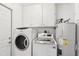 Laundry room with washer, dryer, and overhead cabinets at 9518 W Shasta Dr, Sun City, AZ 85351