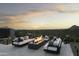Modern patio furniture surrounds a fire pit with mountain views at sunset at 10784 E Pinnacle Peak Rd, Scottsdale, AZ 85255