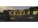 Three-car garage and home exterior at dusk with landscape lighting at 10784 E Pinnacle Peak Rd, Scottsdale, AZ 85255