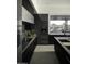 Modern kitchen with dark cabinetry, stone counters, and a view at 10784 E Pinnacle Peak Rd, Scottsdale, AZ 85255