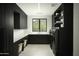 Modern laundry room with dark cabinetry and a window at 10784 E Pinnacle Peak Rd, Scottsdale, AZ 85255