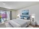 Comfortable bedroom featuring a plush bed, modern lighting, and sliding glass door to outdoor area at 10863 W Thunderbird Blvd, Sun City, AZ 85351