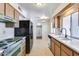 Kitchen with wood cabinets, retro appliances, and tile floors at 10863 W Thunderbird Blvd, Sun City, AZ 85351