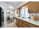 Bright kitchen featuring wood cabinetry, white countertops, and stainless steel appliances at 10863 W Thunderbird Blvd, Sun City, AZ 85351