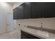 Modern laundry room featuring dark cabinetry and countertop space at 11972 E Yearling Rd # 20, Scottsdale, AZ 85255
