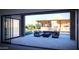 Patio seating area with outdoor kitchen, waterfall feature, and pool view through sliding glass doors at 11972 E Yearling Rd # 20, Scottsdale, AZ 85255