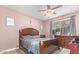 Well-lit bedroom with a wooden frame bed and ensuite access at 17536 W Desert Bloom St, Goodyear, AZ 85338