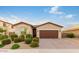 Single-story home with brown garage door and landscaped front yard at 17536 W Desert Bloom St, Goodyear, AZ 85338