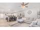Open living room with gray sectional sofa and ceiling fan at 17536 W Desert Bloom St, Goodyear, AZ 85338