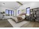 Airy bedroom with vaulted ceilings, hardwood floors, a large window and modern furnishings at 19912 E Karsten Dr, Queen Creek, AZ 85142
