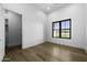 Neutral bedroom with hardwood floors, window, and a white door leading to a walk-in closet at 19912 E Karsten Dr, Queen Creek, AZ 85142