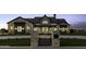 Stunning stone and stucco home with modern black trim and manicured lawn, captured at twilight at 19912 E Karsten Dr, Queen Creek, AZ 85142
