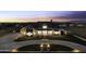 Stunning home featuring a circular driveway, manicured lawn, stone facade and beautiful sunset at 19912 E Karsten Dr, Queen Creek, AZ 85142