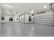 Spacious garage featuring epoxy flooring, LED lighting, and multiple roll-up doors at 19912 E Karsten Dr, Queen Creek, AZ 85142