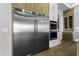 Modern kitchen features stainless steel refrigerator and oven with oak cabinets and gold hardware at 19912 E Karsten Dr, Queen Creek, AZ 85142