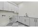 Bright laundry room with white cabinets, quartz countertop, and modern fixtures at 19912 E Karsten Dr, Queen Creek, AZ 85142