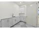 Clean laundry room featuring ample counter space, white cabinetry, and sleek hardware at 19912 E Karsten Dr, Queen Creek, AZ 85142